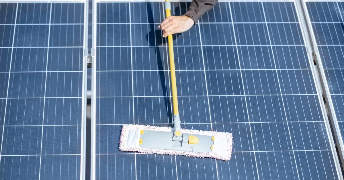 a person cleaning a solar panel - how do you know when it is time to clean solar panels